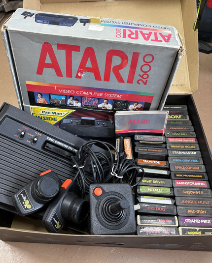 Atari 2600 with assorted games, booklets and original box.