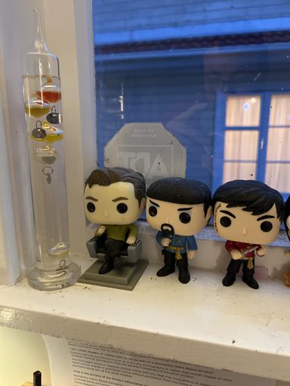 Galileo Thermometer on a windowsill with the above described pop! Vinyls.