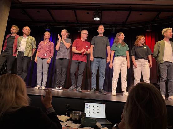 10 Menschen auf einer Bühne