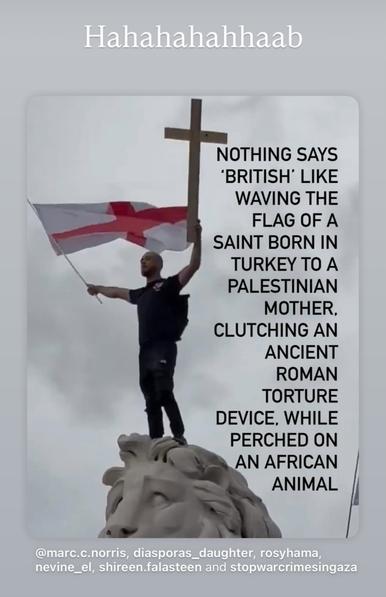 The flag of England and a crucifix held aloft a Statue of a Lion.