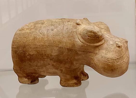 A small carved stone figurine of a hippopotamus with rounded features and a smooth, worn surface, displayed on a white background