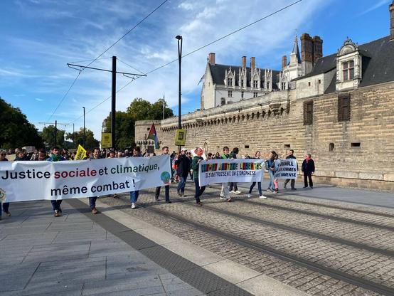 Groupes de personnes portant des banderoles sur le climat, la justice et la liberté.