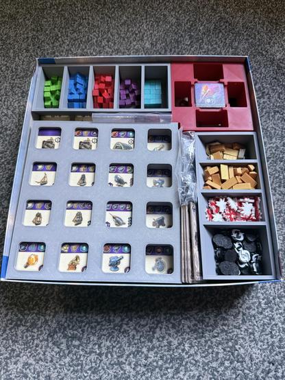 Anno 1800 box. Lid is off and it shows a 3D printed insert. Grey gird bottom left. Resource trays to the right and top.