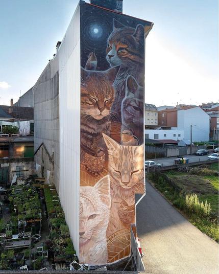 fresque peinte le mur latéral d'un immeuble assez haut (au moins 6 étages) mais peu large, ça donne une bande verticale, au milieu d'un jardin et d'un carré d'herbe. On voit 5 chats et 2 ou 3 oiseaux. Le bas du mur est clair, le pelage des chats occupe tout l'espace. En haut c'est l'inverse, le fond est noir et le pelage sombre est éclairé par le halo d'une lune pleine.