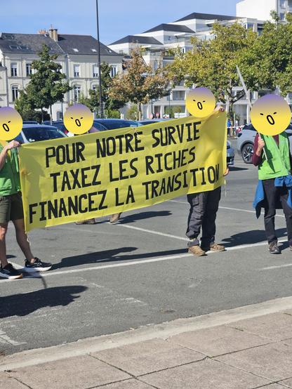 Photo d'une banderole tenue "Pour notre survie taxes les riches, financez la transition"