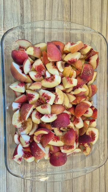 Gezuckerte Pfirsiche in Stücken in Auflaufform aus Glas