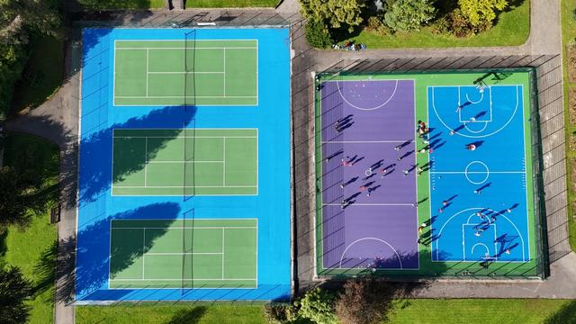 Top-down image of children using the upgraded Blakemore sports court, featuring multi-coloured surfacing and markings funded through Welsh Government’s infrastructure programme.