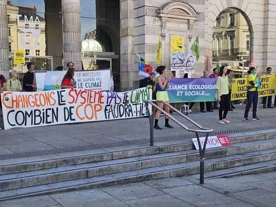 Photo finale sur les marches du théâtre. Avec de multiples banderoles appelant a plus de justices écologiques et sociales.