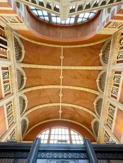 Ceiling of a railway station taken with wide angle. It is a mix of red bricks and white lime stone. Big window as can be seen in the front and back.