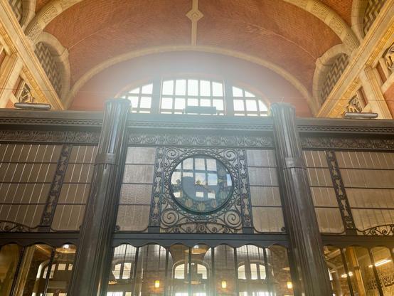 The old ticketing office, in black steel, now repurposed as coffee shop, with a big clock in the middle.
