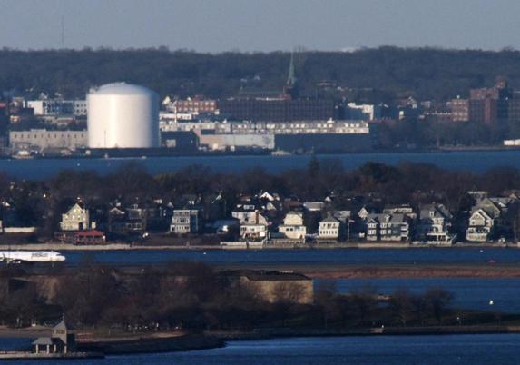 St Joseph's Church, 115 Union St, Lynn MA photographed from Buck Hill. The olive green spire is a little hard to pick out against the brown background and the tip of the spire only just rises above the land behind it.