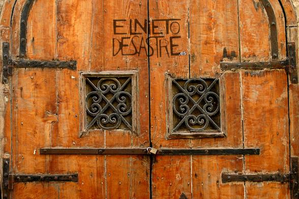 La puerta trasera de una casa, de madera y hierro.