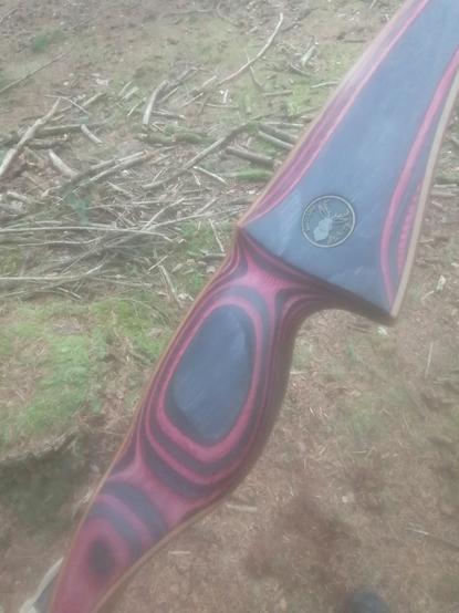 Das Griffstück eines traditionellen Bogens, Fabrikat "Red Beryl".

Der Bogen besteht aus einem künstlichen Holz-Werkstoff in den Farben schwarz und rot, er ist belegt mit einem Bambus-Laminat und dunkler Carbonfaser.