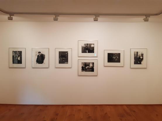 Blick in einen Galerieraum. An einer weißen Wand hängen schwarz-weiß-Fotografien