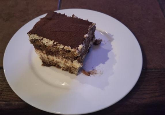 Foto van een vierkant stuk tiramisu op een bord