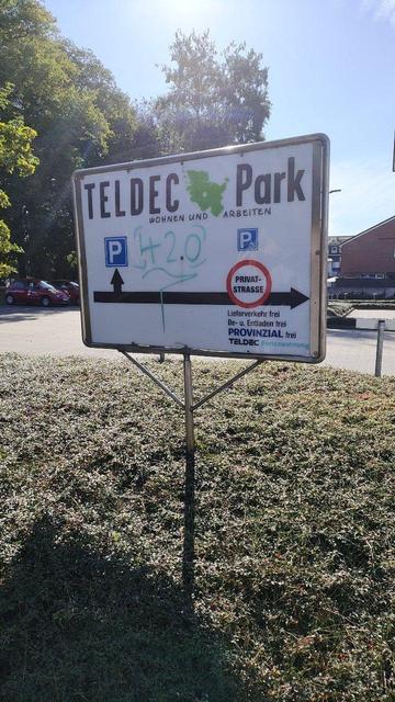 Schild "TELDEC Park". Es steht auf einem Grünstreifen auf dem Gelände.