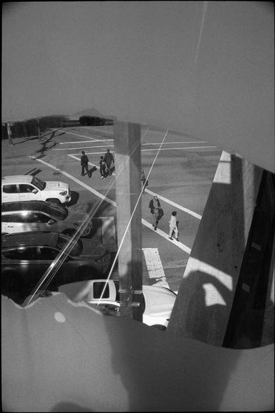 A look down on pedestrians as they navigate a busy intersection.