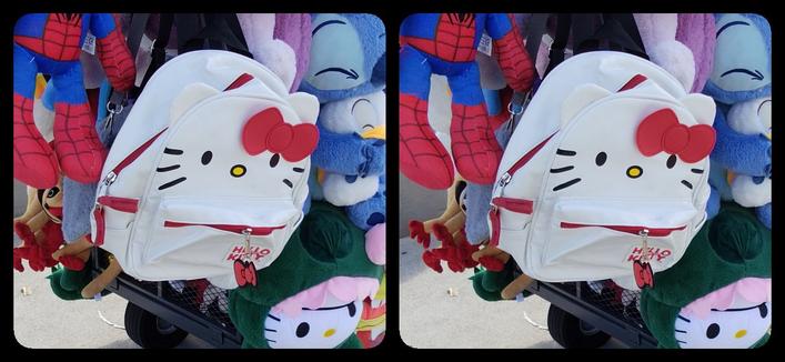 Among a lot of other stuffed toys and other bags is a white Hello Kitty backpack with a red zipper that looks like her mouth, and makes her look like Alley-Oop or Nigel Farage.
