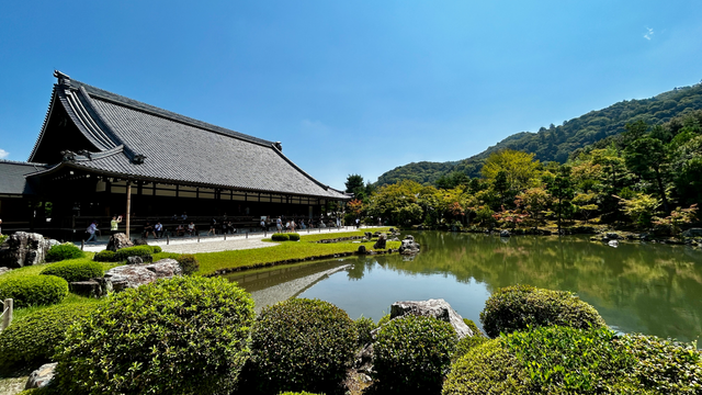 a japanese temple next to a small lake