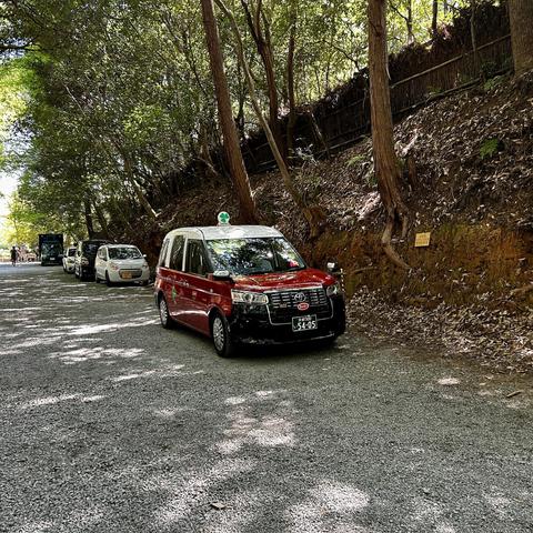 a typically red colored taxi in Kyoto next to bamboo forest