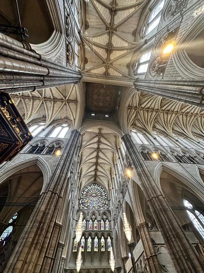 looking up at the crossing, which has a higher ceiling than the ribbed vaulted ceilings of the transept and nave. at bottom is one of the transepts' gigantic rose stained glass windows.