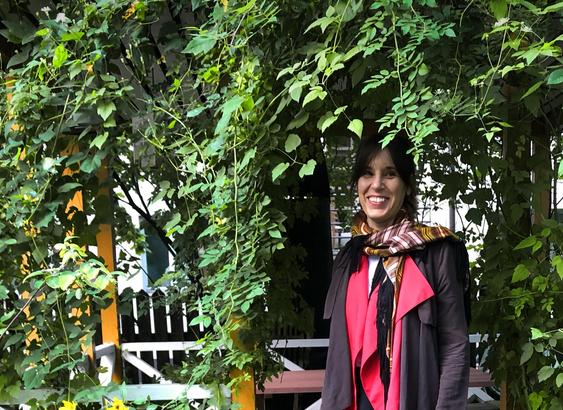 Artist Terike Haapoja standing in front of a gazebo, smiling
