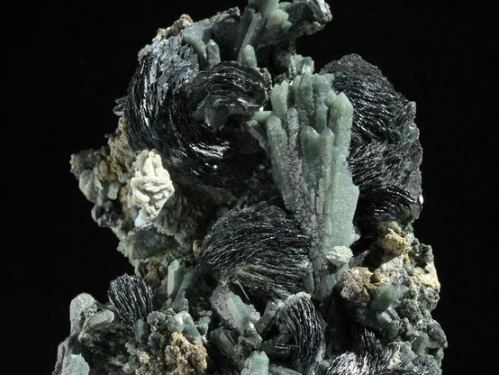 Spectacular silver #Hematite iron roses (sculptural, tabular crystals that form rose-like petals & clusters) with prasem quartz (colored green by acicular inclusions of actinolite) forms an ocean floor seascape.  From Mongolia. Photo source: https://www.ebay.it/itm/141193859226
