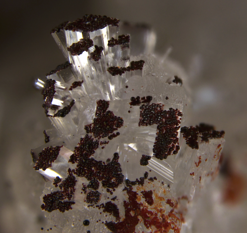 Hematite from Francon Quarry, Montreal, Quebec. MinDat photo by Chris Emproto (sampled by Steve Chamberlain) the hematite is on Dawsonite NaAlCO3(OH)2.
The small hematite spheres are on the end of the columns of clear dawsonite.