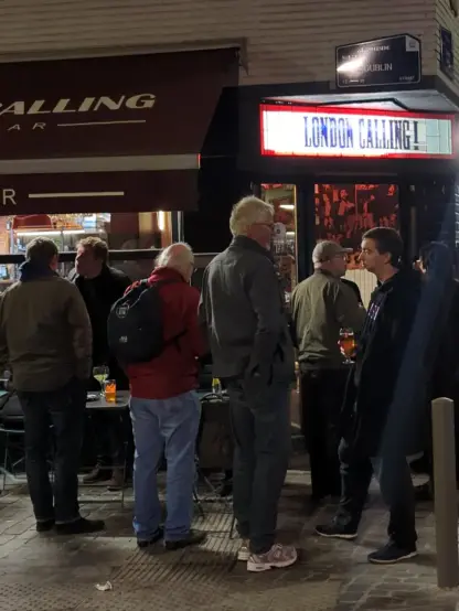 People standing in Front of a pub.
The sign: London Calling!