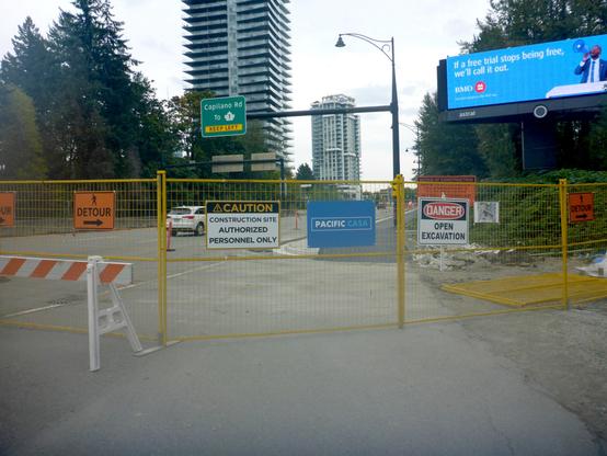 Almost completed multi-use path behind a yellow construction fence.
