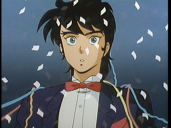 Ryo is in a fancy dinner jacket looking thing with a red bowtie. He has a suprised look on his face as confetti falls around him.