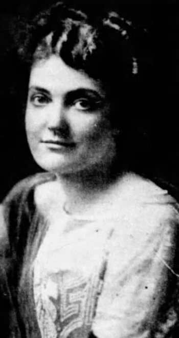 Mabel Sykes in the 1920s, a youngish white woman with dark hair, wearing a light dress with an embroidered or beaded bodice