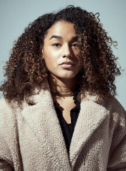 Photograph of a woman in a fluffy coat.