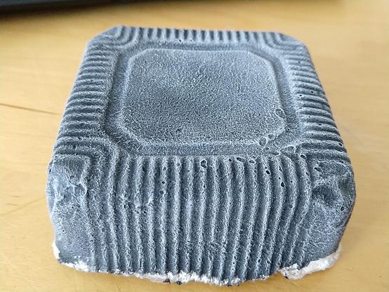 A rectangular slab-shape, with lots of ridges along the line, giving it a alien or SciFi vibe. It was made from a mochi container used as mold.