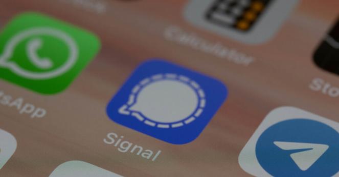 Screenshot eines Smartphone-Displays, auf dem in der Mitte das Icon von Signal zu sehen ist. Links und rechts davon WhatsApp und Telegram.