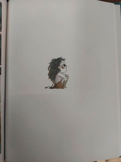 Una de las páginas del cómic, donde sobre fondo blanco, en medio de la página hay un dibujo de Elma. Está sentada de perfil, con los brazos cruzados y apoyados sobre las rodillas. Tiene el pelo azul, ojos grandes y redondos, y viste una falda hecha de hojas. Mira hacia arriba.