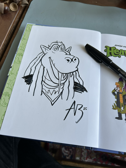 A book with a pen drawing of a cartoony dragon