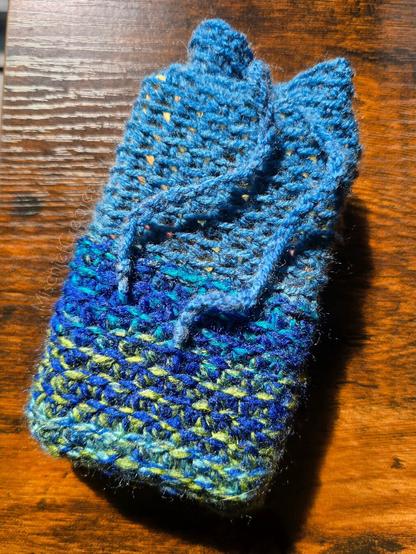 A crochet tarot card pouch that is blue and green.