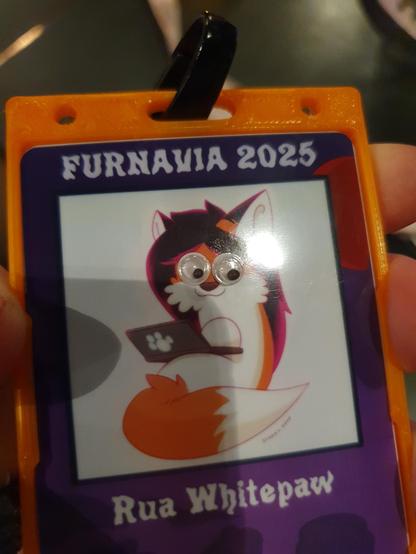 My conbadge for Furnavia, with little googly eyes stuck on top of my face.