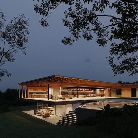 A modern wooden house at dusk, featuring large windows, a pool, and an inviting terrace illuminated by warm light.