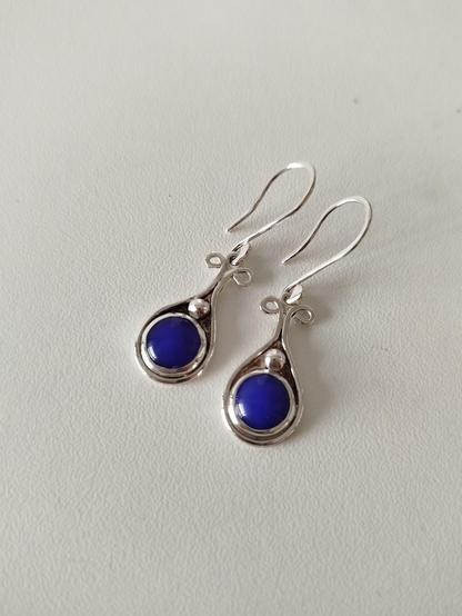 a pair of dangle drop silver earrings with a round blue stone