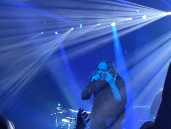 Der Sänger von Dark Tranquility auf blau beleuchteter Bühne