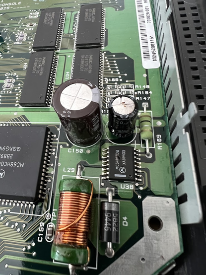 The motherboard of a broken Atari Jaguar, showing a bulged capacitor and a blown U38 component (switching regulator), all likely from having the wrong polarity power supply used.
