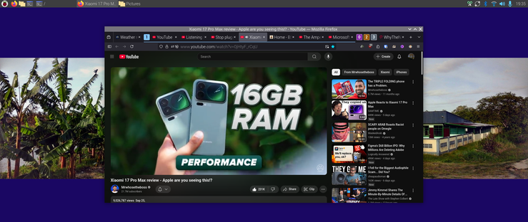 The image shows a computer screen with a YouTube video open in the center. 
16GB of super fast ram is accentuated here
The video is titled "Xiaomi 17 Pro Max review - Apple are you seeing this?" and features an advertisement for the Xiaomi 17 Pro Max smartphone, highlighting its "16GB RAM" and "PERFORMANCE." The video has 9,257,767 views and was uploaded on September 23. On the left side of the screen, there is a thumbnail of a banana plantation, and on the right, a thumbnail of a house with a blue roof. The browser tabs at the top include "Xiaomi 17 Pro M," "Pictures," "Weather," "YouTube," "Listening," "Stop," "Apple," and "Xiaomi." The time displayed is 19:35.