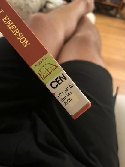 Photo of the spine of Other Networks by Lori Emerson, with the brand new library call number and “new book” tag attached.