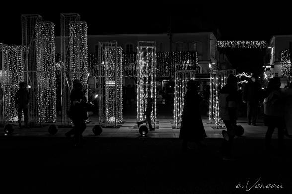 Shadows of protesters with candles, a child jumps past Christmas decorations