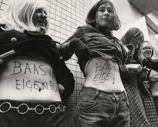 Zwart wit foto, vrouwen op een rijtje met tekst op hun buik: baas in eigen buik