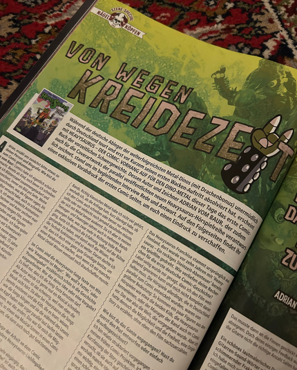 Magazine page with lots of text. Title: VON WEGEN KREIDEZEIT. The „I“ of the last word is a dinosaur hand doing the metal hand sign