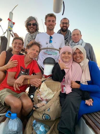 Ground photo of final crew of the saling vessel Mikeno: Eight brave souls on a sailboat.