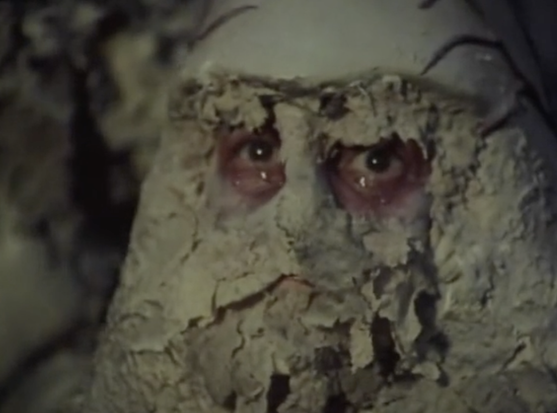 One alien looks up at Blake, tears falling from it's all-too-human eyes